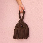 Handmade crochet mini swing bag in Coconut Shell brown with flowing fringe and a loop-through wristlet handle.