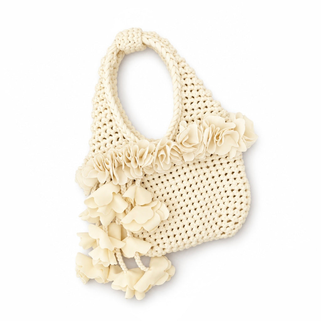 Handmade crochet petal bell mini bag in magnolias cream with braided handle and cascading petal trim. 