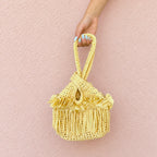 Handmade crochet mini swing bag in Daffodil light yellow with flower fringe and a loop-through wristlet handle.