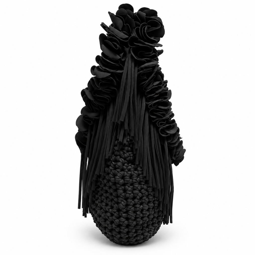 Onyx black hand-crocheted Flower Lei Mini bag with cascading floral ruffles and fringe, featuring a braided handle and sculptural mini silhouette.