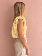 Daffodil yellow hand-crocheted Flower Lei Mini bag with cascading floral ruffles and fringe, featuring a braided handle and sculptural mini silhouette.