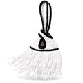 Handmade crochet mini swing bag in Gardenia white with flowing fringe, Onyx black trim and a loop-through wristlet handle.