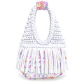Gardenia white handmade crochet fringe mini bag with UV-reactive beads transforms into pink, purple, peach and pearly tones in daylight and glow-in-the-dark, fluorescent glowing green tones at nighttime. 