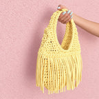 Handmade Daffodil light yellow crochet fringe mini bag with flowing fringe and a braided handle.