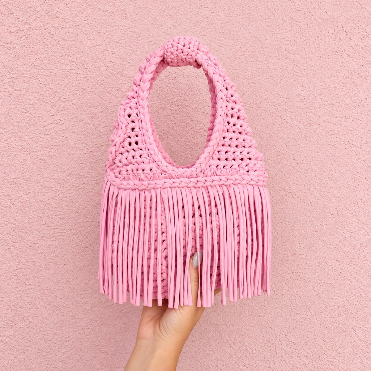 Handmade Petal pink crochet fringe mini bag with flowing fringe and a braided handle.