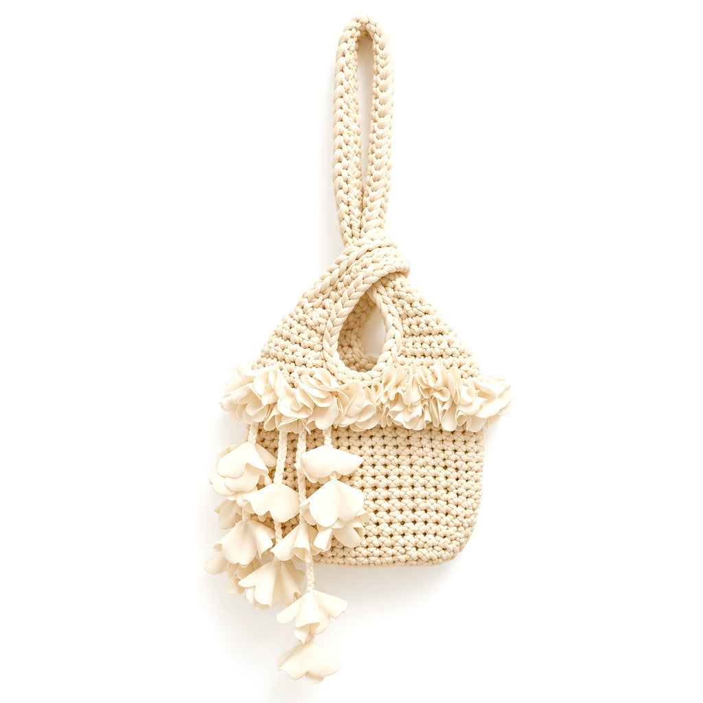 Handmade crochet petal bell mini swing bag in magnolia cream with a loop through wristlet handle and cascading petal trim. 