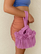 Handmade crochet mini swing bag in Orchid pink purple with flower fringe and a loop-through wristlet handle.