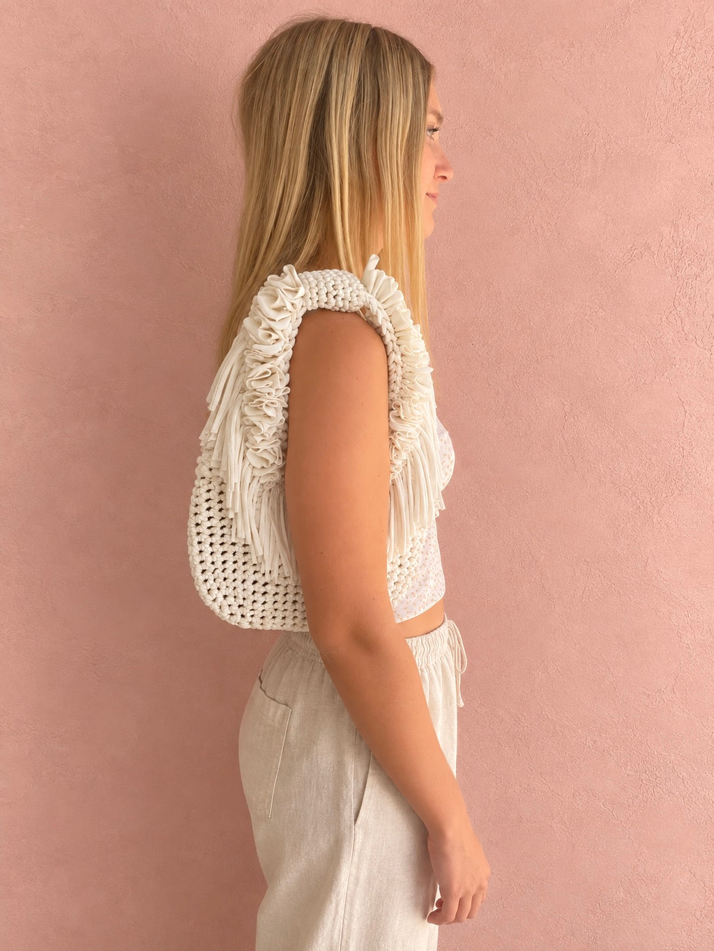Gardenia white hand-crocheted Flower Lei Mini bag with cascading floral ruffles and fringe, featuring a braided handle and sculptural mini silhouette.