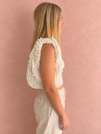 Gardenia white hand-crocheted Flower Lei Mini bag with cascading floral ruffles and fringe, featuring a braided handle and sculptural mini silhouette.