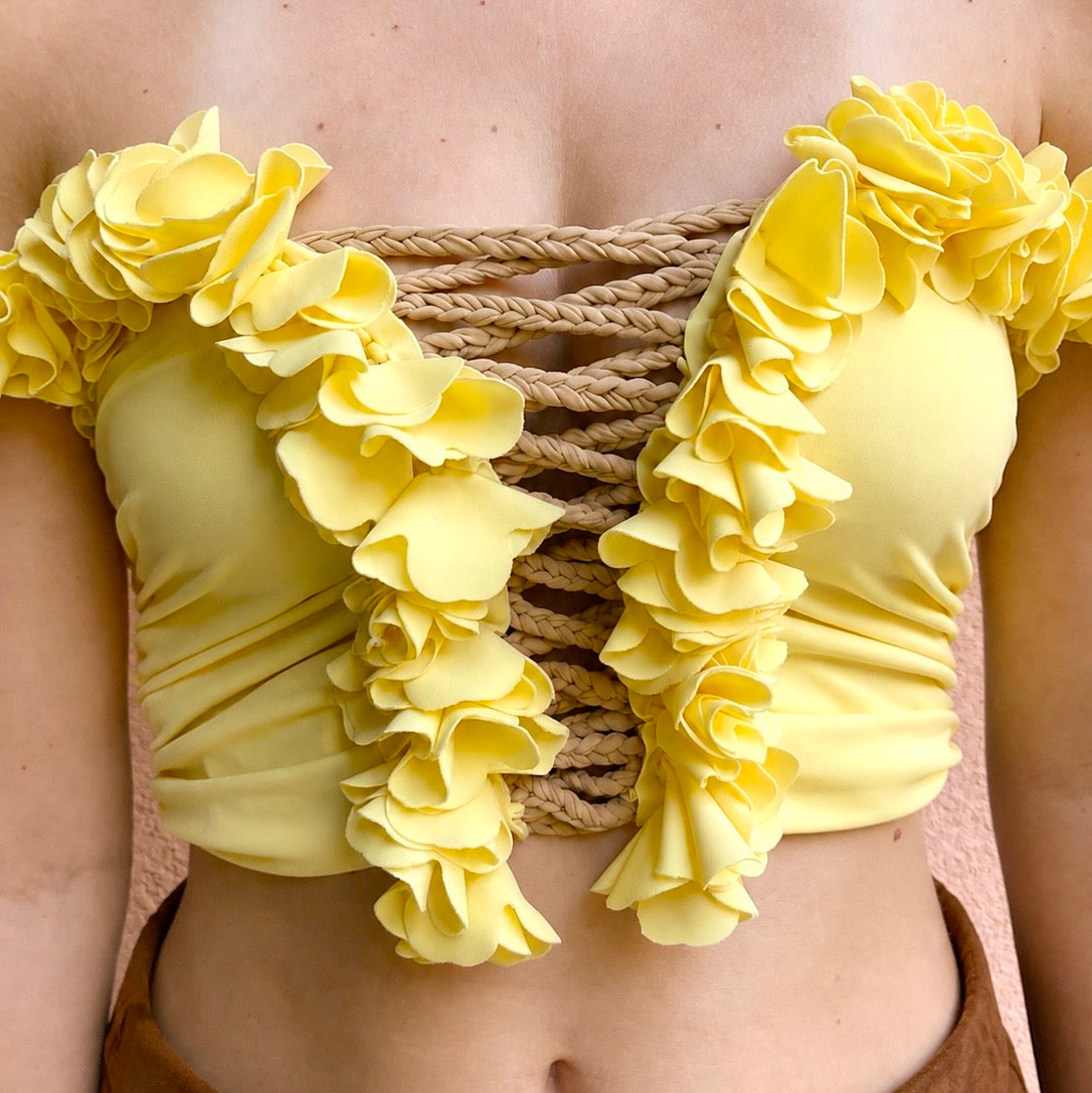 Daffodil yellow floral off-the-shoulder crop top with flower lei trim and hand-crocheted lace-up center detail.