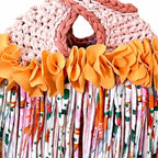 Handmade crochet mini swing bag in Desert Bloom tan with orange flower fringe and a loop-through wristlet handle.
