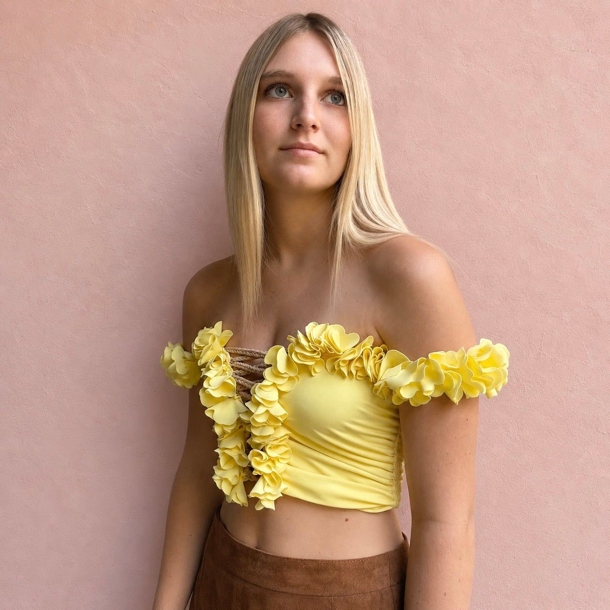 Daffodil yellow floral off-the-shoulder crop top with flower lei trim and hand-crocheted lace-up center detail.
