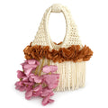 Handmade magnolia cream crochet whimsy mini bag with cascading fringe, metallic pink and copper petal bell trim and a braided handle. 