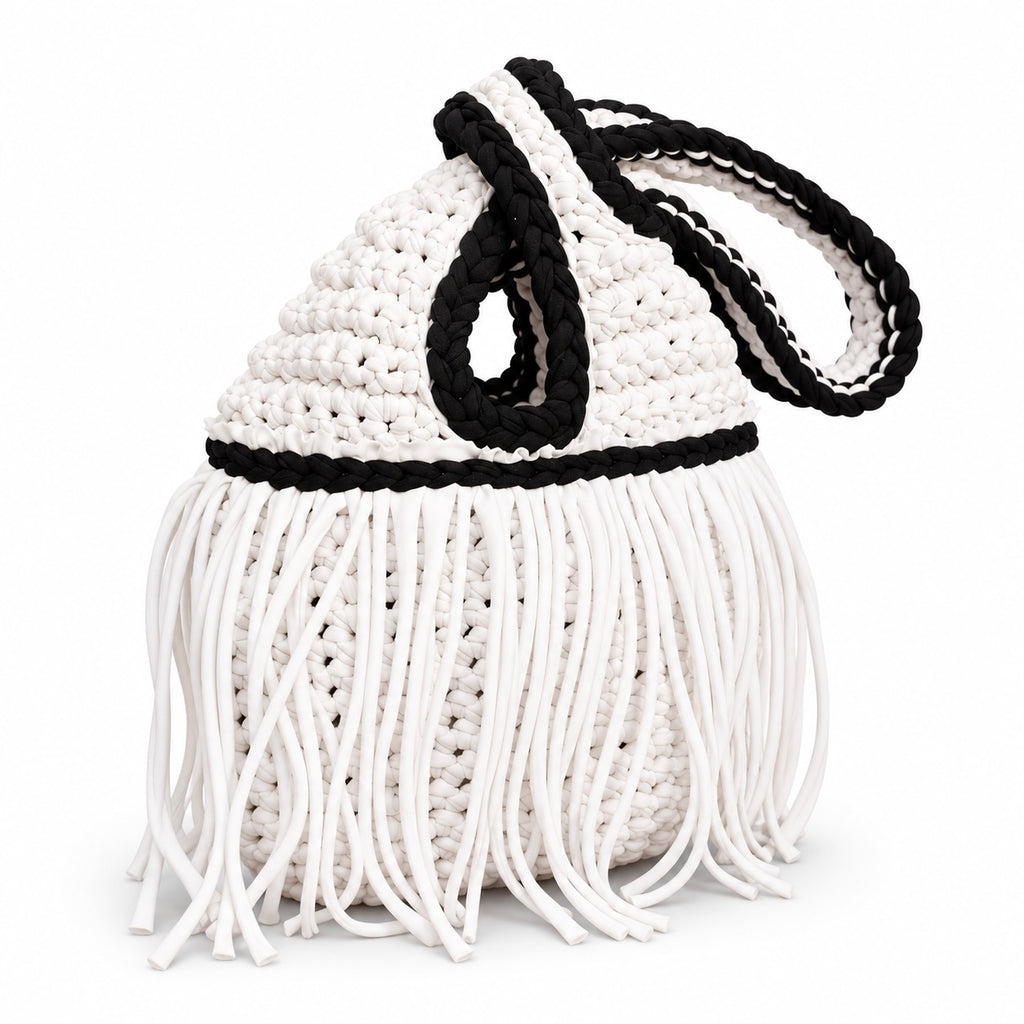 Handmade crochet mini swing bag in Gardenia white with flowing fringe, Onyx black trim and a loop-through wristlet handle.