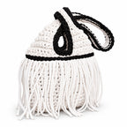 Handmade crochet mini swing bag in Gardenia white with flowing fringe, Onyx black trim and a loop-through wristlet handle.