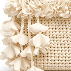 Handmade crochet petal bell mini swing bag in magnolia cream with a loop through wristlet handle and cascading petal trim. 