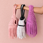 Handmade crochet mini swing bags in Gardenia white, Petal pink or Orchid purple with flowing fringe and a loop-through wristlet handle.