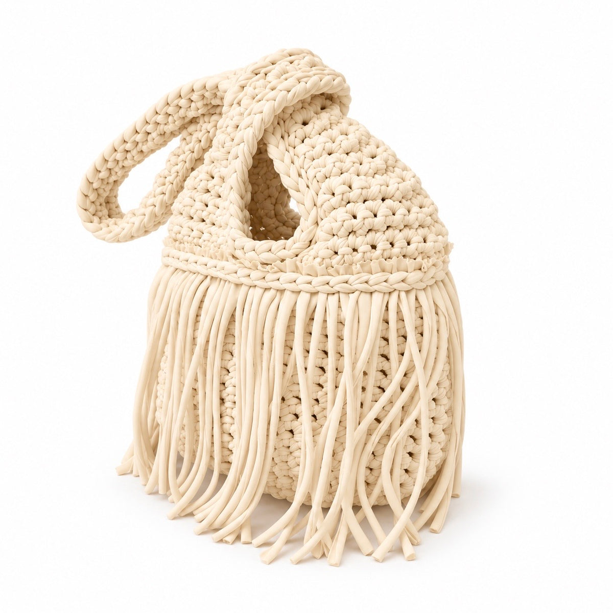 Handmade crochet mini swing bag in Magnolia cream with flowing fringe and a loop-through wristlet handle.