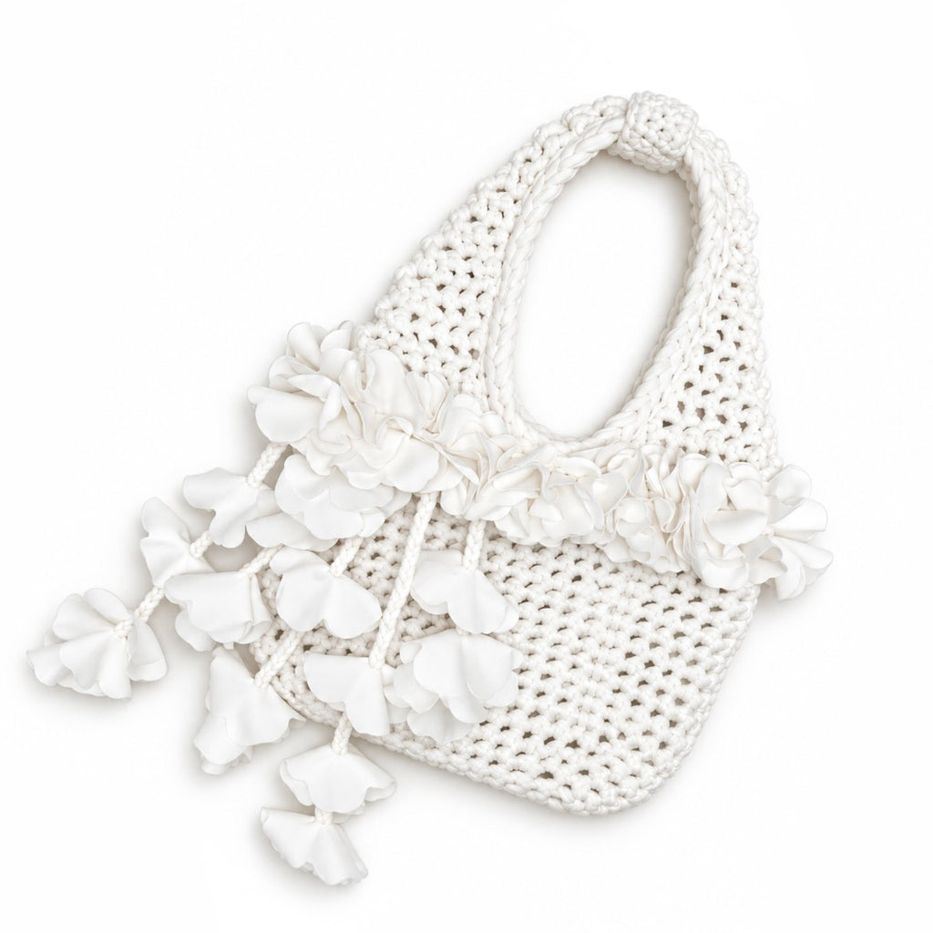 Handmade crochet petal bell mini bag in gardenia white, with braided handle and cascading petal trim. 