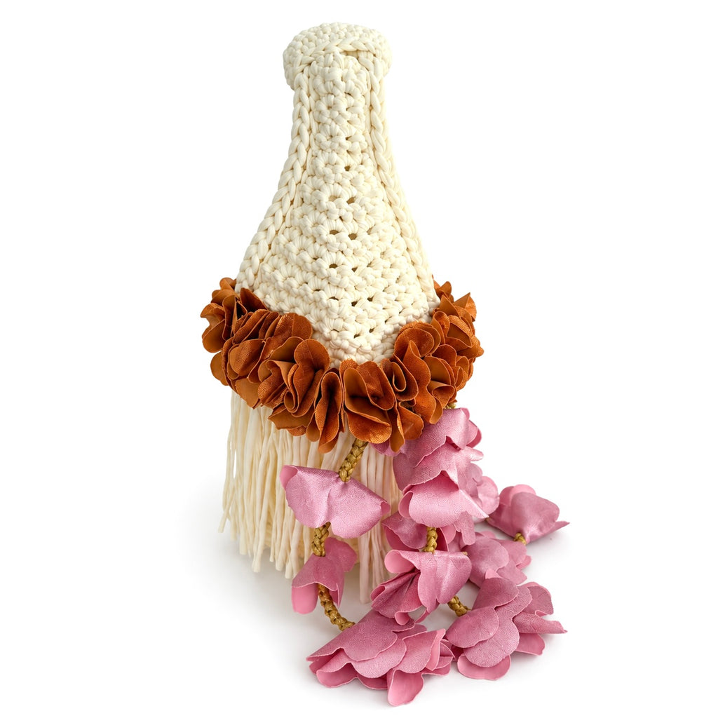 Handmade magnolia cream crochet whimsy mini bag with cascading fringe, metallic pink and copper petal bell trim and a braided handle. 